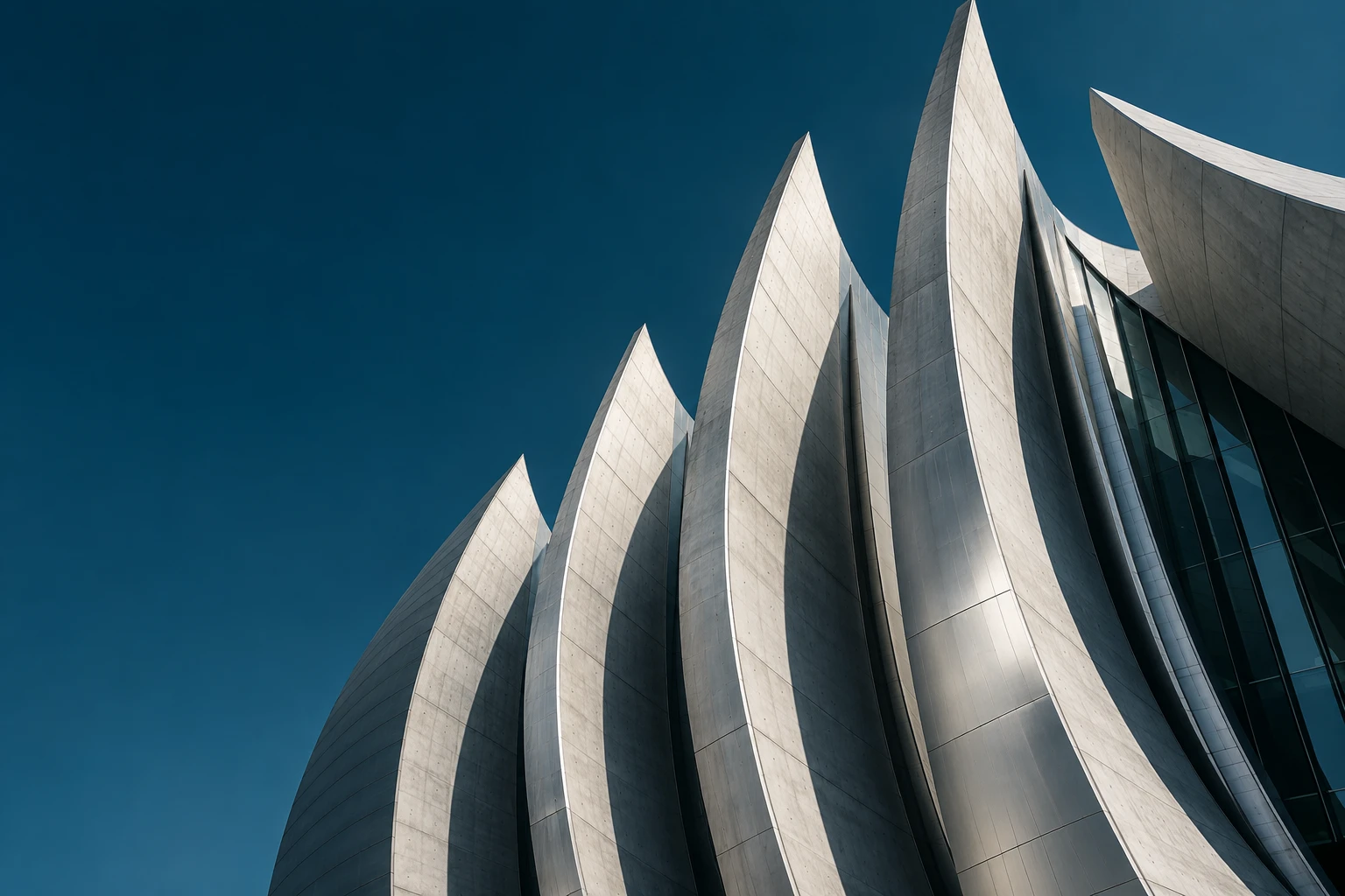 Sculptural modern architecture rising into a deep teal sky